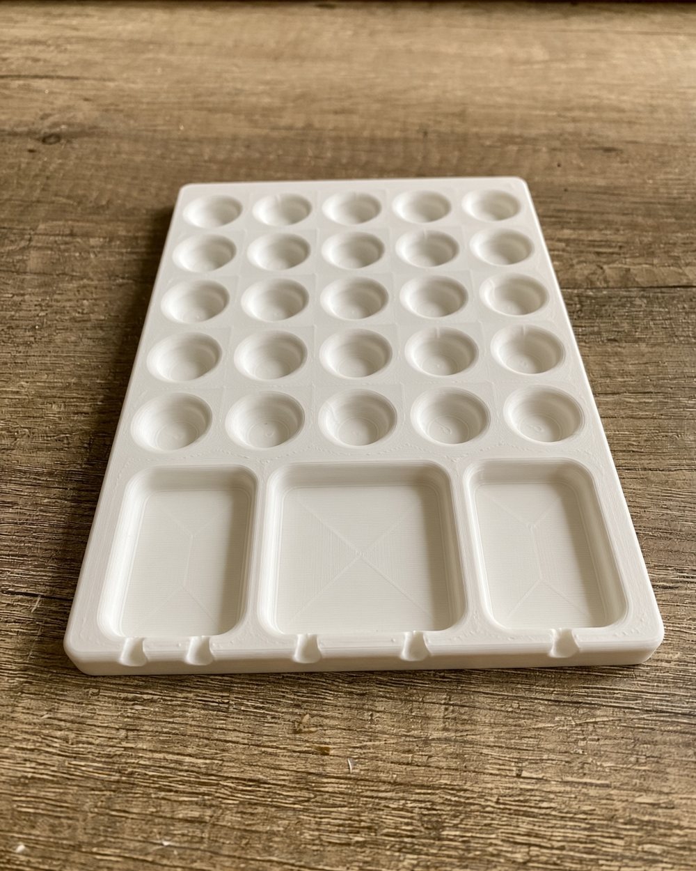 Our 3D-printed white paint palette with round wells and mixing trays